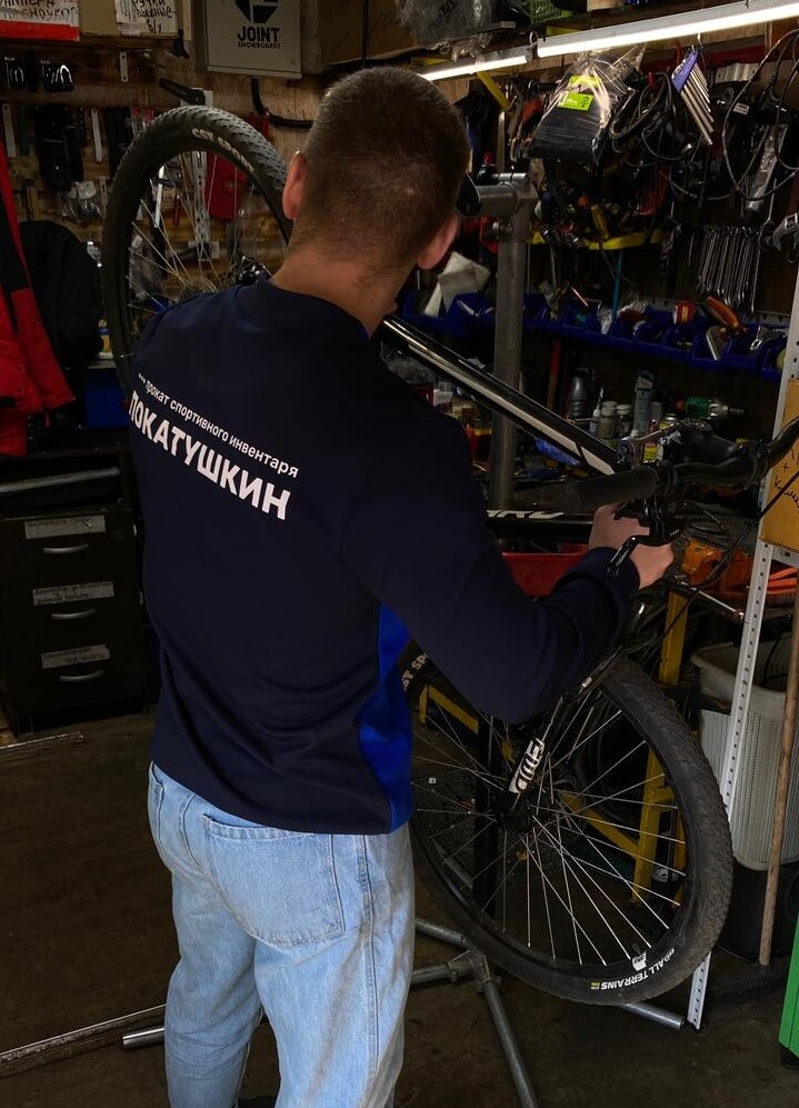 Сотрудник Покатушкина обслуживает велосипед
